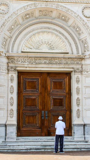 Negative space picture of man standing in front of large door